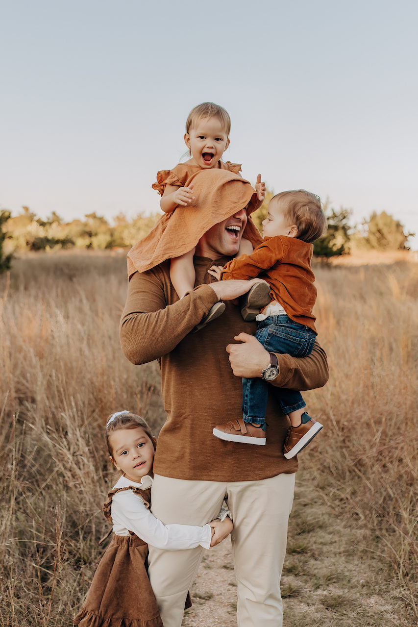 Earthy brown family photo color schemes for dad and siblings at this San Antonio field photography session.