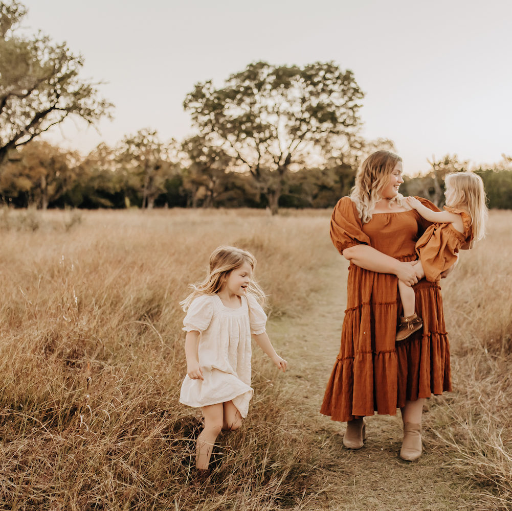 Family photography session in a in Boerne, Texas in a field of tall grass, golden light, and pretty trees.