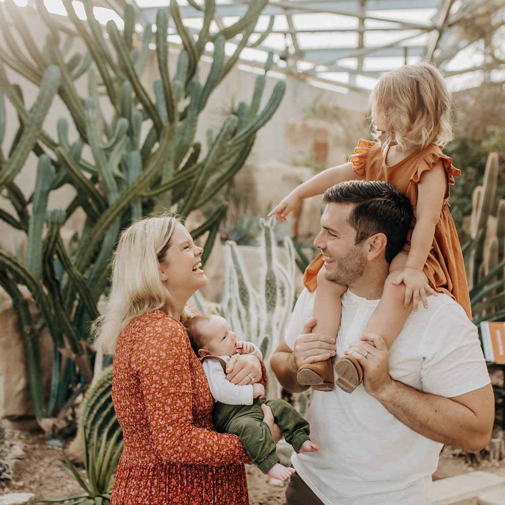 A family smiling and laughing while getting their family photos made at The San Antonio Botanical Garden.